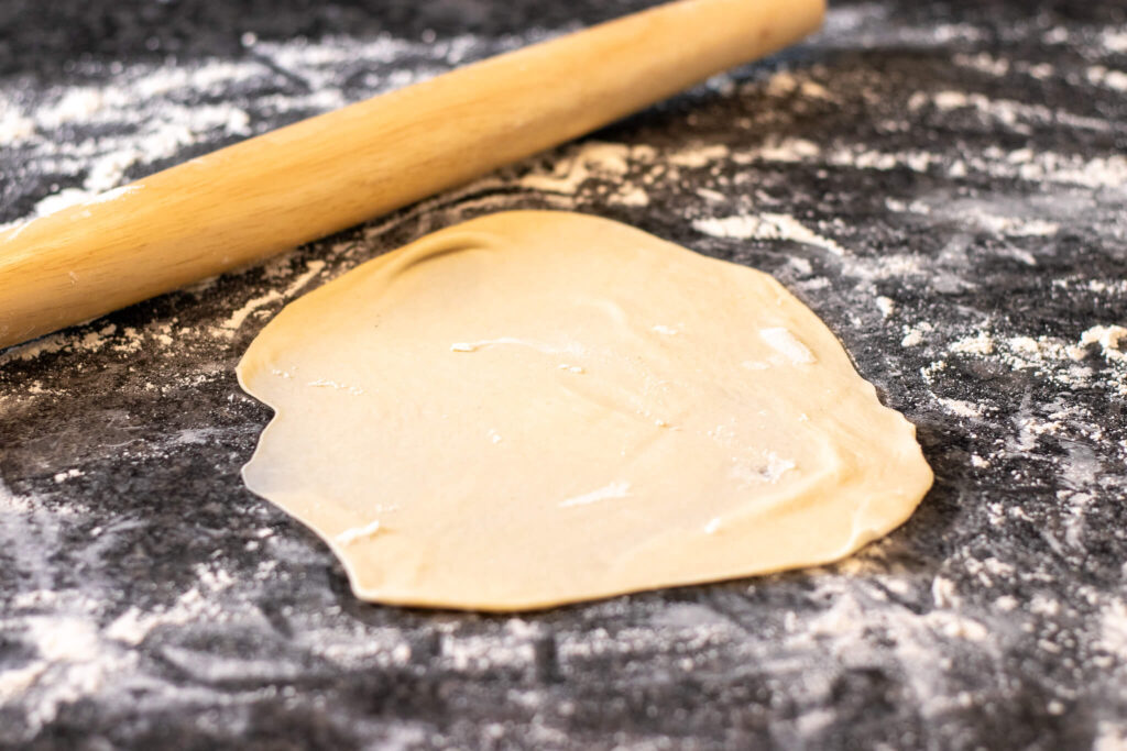 tortilla rolled out on a floured surface