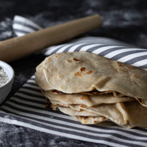 lard tortillas with flour in a bowl and a rolling pin