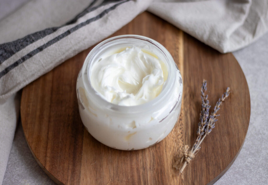 whipped tallow balm on a circular wooden cutting board