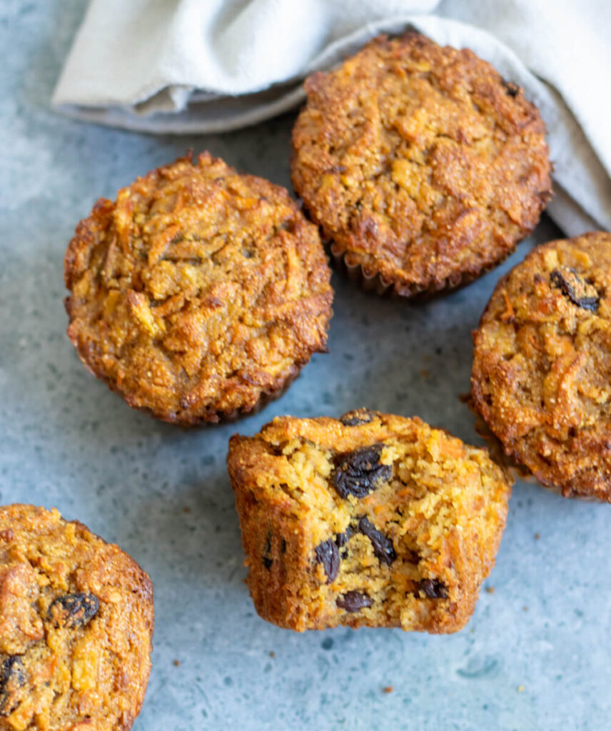 5 carrot raisin muffins on a grey surface